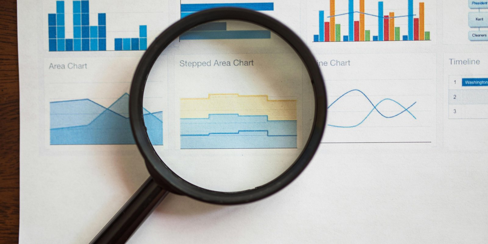 A magnifying glass over a page of charts